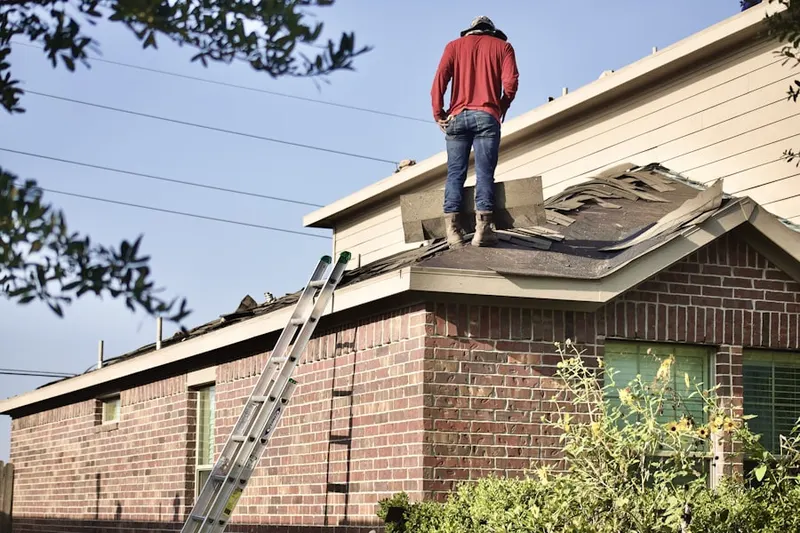 Professional roofer working on a residential roof in Andrews Estates